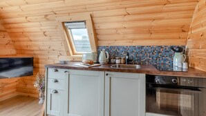 Eine Küche mit Holzwänden, einer gefliesten Rückwand und einem Oberlicht.