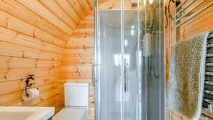 A wooden interior with a glass-enclosed shower, a toilet, and a sink. - 1 Bed in Crediton (oc-p28229) (Crediton Hamlets)