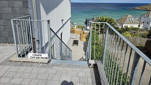 A staircase leading to a balcony with a view of the sea, a sign reading 'LOWER CHY-AN-MEOR,' and a metal railing. - 4 Bed in St. Ives (oc-c28788) (St Ives)