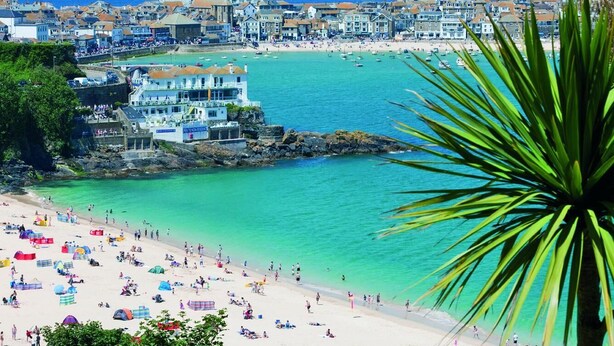 A coastal town with a beach, buildings, and a prominent cliff. - 4 Bed in St. Ives (oc-c28788) (St Ives)