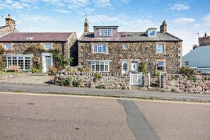 A stone building with multiple windows and a gated entrance. - 4 Bed in Craster (oc-t28831) (Dunstan)