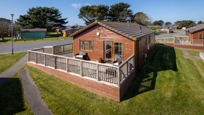 A wooden cabin with a balcony, a small porch, and a clear view of the surrounding area. - 3 Bed in St. Merryn (oc-s28856) (Penrose)