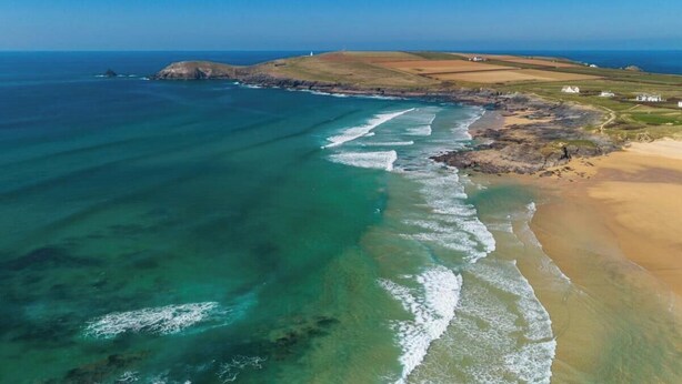 A coastal landscape with clear waters, sandy beach, and distant buildings. - 3 Bed in St. Merryn (oc-s28856) (Penrose)