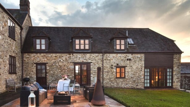 A stone building with a large patio area, outdoor seating, and a well-maintained lawn. - 3 Bed in Upottery (oc-t28827) (Upottery)