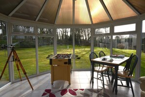 A conservatory with a foosball table, chairs, and a telescope. - 3 Bed in Goldsithney (oc-b28811) (Goldsithney)