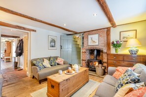 A cozy living room with a fireplace, a sofa set, and a wooden coffee table. - 2 Bed in Langham (oc-t28836) (Langham)
