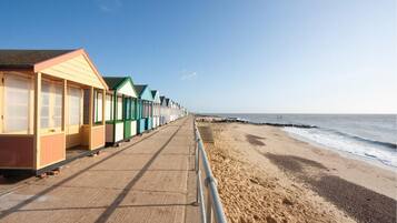 A row of beach huts along a seaside promenade.