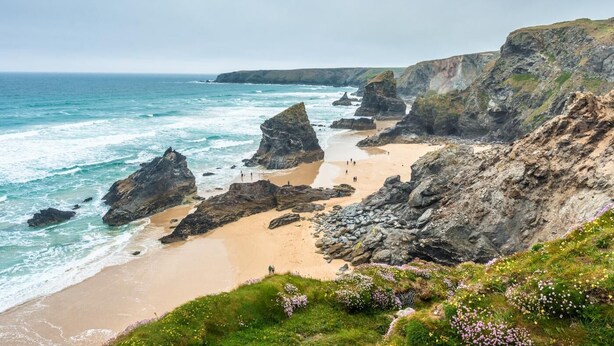 A coastal landscape with rocky cliffs, a sandy beach, and a clear view of the ocean. - 4 Bed in Retorrick Mill (oc-w28897) (Saint Mawgan)