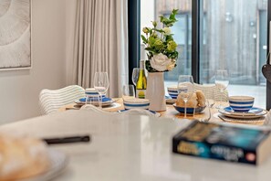 A dining table set with blue and white plates, glasses, and a bottle of wine. - 2 Bed in Harlyn Bay (oc-s28921) (Harlyn Bay)