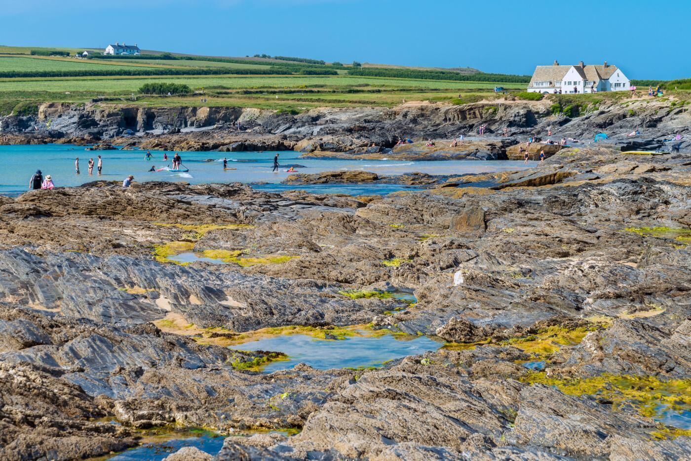 A rocky coastal area with people engaging in water activities.