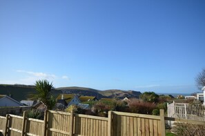 A residential area with houses, a wooden fence, and hills in the background. - 3 Bed in Hope Cove (oc-hocov) (Hope Cove)