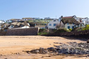 A sandy beach with thatched-roof houses in the background. - 3 Bed in Hope Cove (oc-hocov) (Hope Cove)