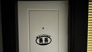A white door with a welcome sign featuring two chairs and the word "WELCOME" above them. - Charming 2 BR 1BA Basement suit in White Rock with WiFi (White Rock)