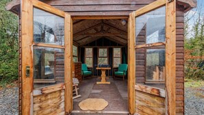 Een houten chalet met een gezellig interieur, met een eettafel en twee stoelen.