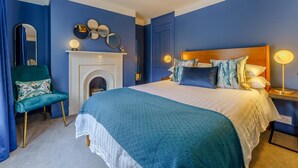 A bedroom with a large bed, a fireplace, a chair, and a mirror. - 3 Bed in Canterbury (oc-86139) (Canterbury)