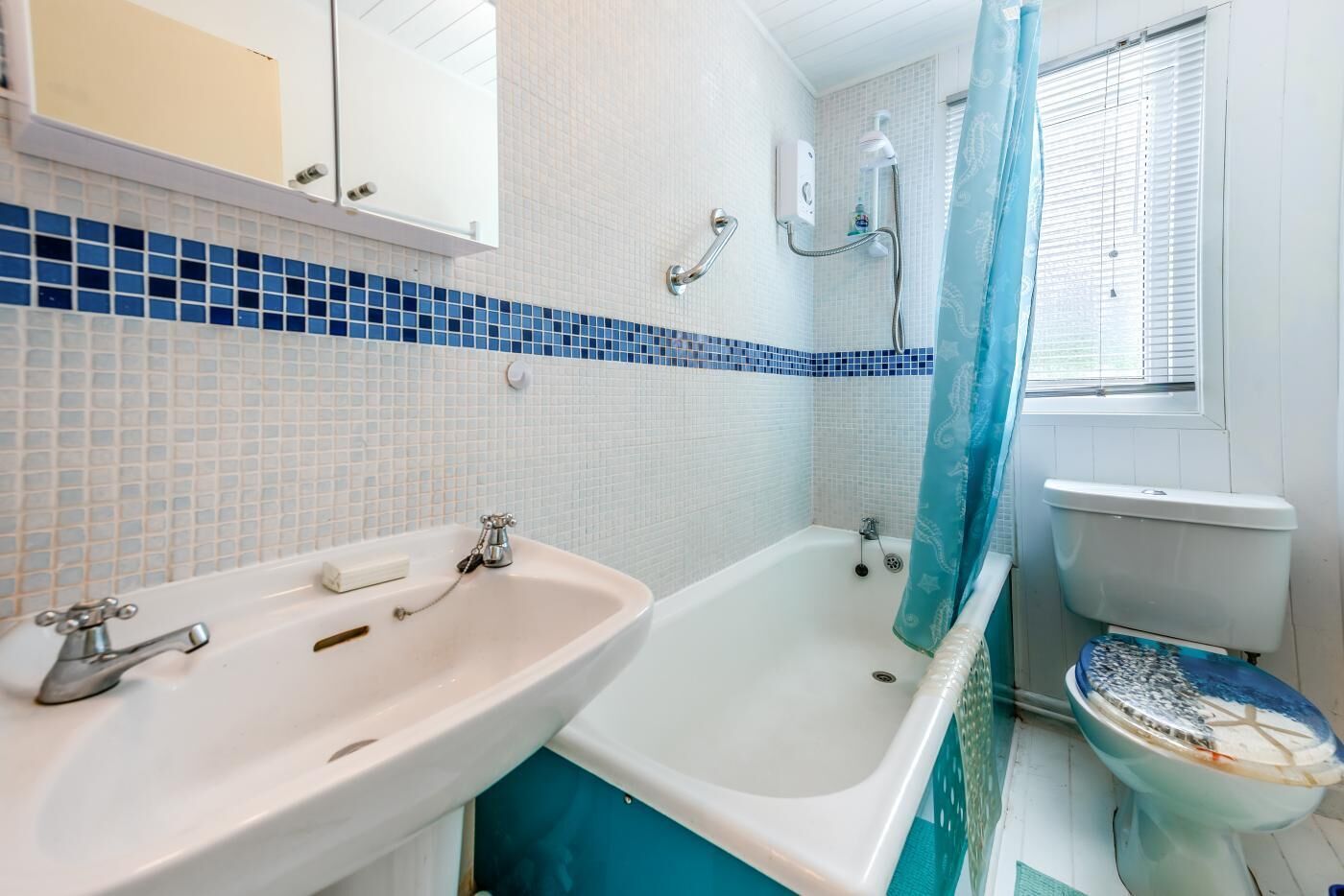 A bathroom with a white sink, a bathtub, and a toilet.