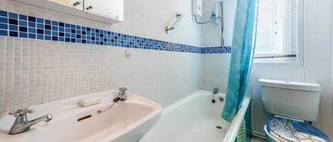 A bathroom with a white sink, a bathtub, and a toilet.