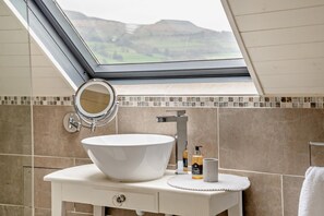A skylight above a bathroom vanity with a large vessel sink, a mirror, and toiletries. - 9 Bed in The Dardy (oc-t28942) (Crickhowell)