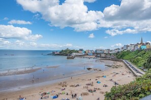 A coastal town with a sandy beach, a pier, and colorful buildings along the shore. - 2 Bed in Tenby (oc-w28987) (Tenby)