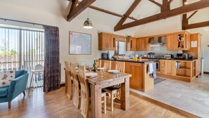 A spacious kitchen with wooden cabinets, a dining area with a table and chairs, and a large window providing natural light. - 3 Bed in Thwing (oc-t29011) (Thwing)