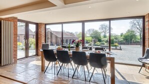A dining area with a large table, chairs, and a view of the outside. - 4 Bed in Thwing (oc-t29013) (Thwing)