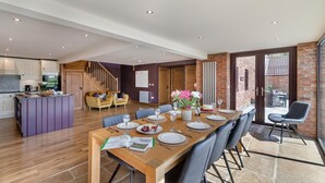 A spacious dining area with a long wooden table set for six, surrounded by modern chairs. - 4 Bed in Thwing (oc-t29013) (Thwing)