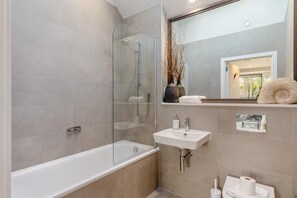 A modern bathroom with a glass-enclosed shower, a white sink, and a mirror reflecting a vase and towels. - 2 Bed in Padstow (oc-t29016) (Padstow)