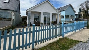 Ein Wohngebiet mit Häusern, einem blauen Weidezaun und blauem Himmel.