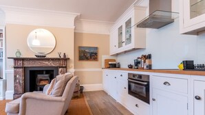 Een moderne keuken met witte kastjes, een inbouwoven en een houten aanrecht.