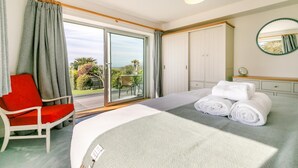 Une chambre d’hôtel avec un lit, une chaise, une table et une vue sur l’extérieur.