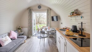 Eine gemütliche Küche mit Essbereich, einer Couch und einem Fernseher.
