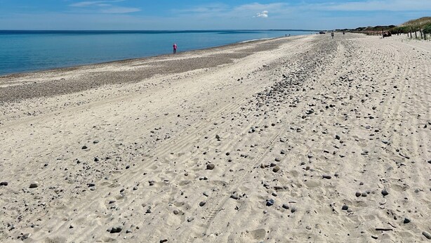 A wide sandy beach with a clear blue sky and calm sea. - 103 North Shore Blvd Unit 1 (Sandwich)