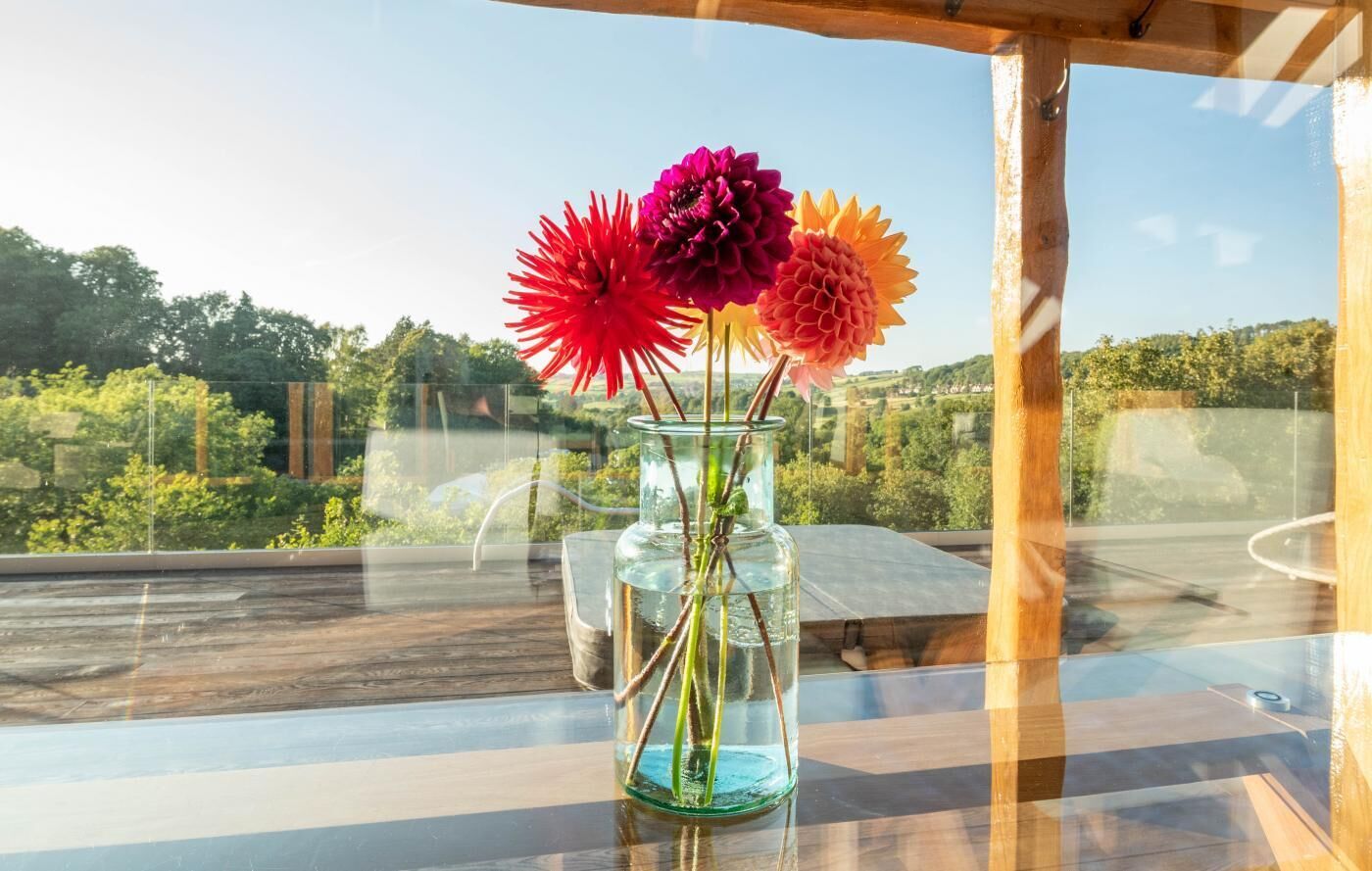 A clear view of a balcony with a glass table holding a vase with flowers.