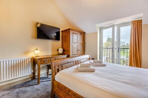 A bedroom with a bed, a desk, a TV, and a view of the outdoors. - 1 Bed in Pershore (oc-t29051) (Pershore)
