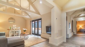 A spacious living area with a dining table, chairs, a sofa, and a TV mounted on the wall. - 2 Bed in Heveningham (oc-w29029) (Heveningham)