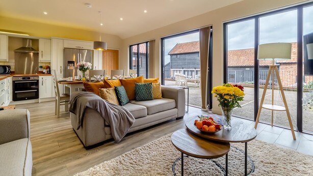 Un salón moderno con un sofá, una mesa de centro y vistas al exterior.