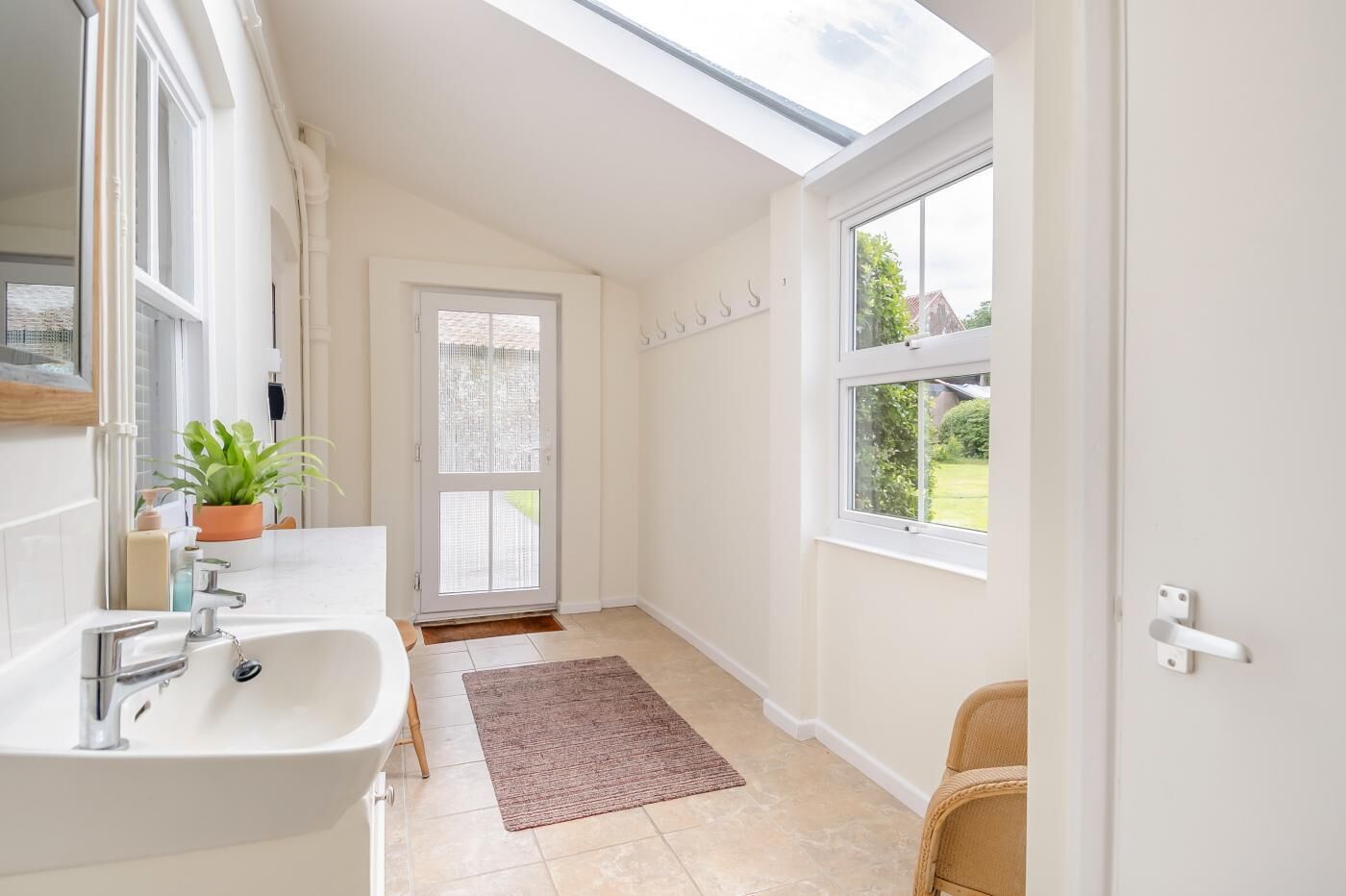A modern bathroom with a skylight, a large window, and a view of the garden.