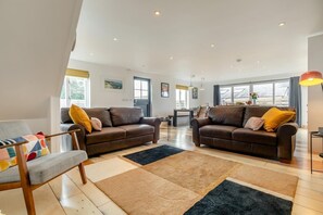 A spacious living room with two sofas, a dining table, and a large window. - 3 Bed in Mawla (oc-l29154) (Mawla)