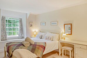 A bedroom with a bed, a desk, a chair, a window with curtains, and wall-mounted pictures. - 2 Bed in Boscastle (oc-f29161) (Boscastle)