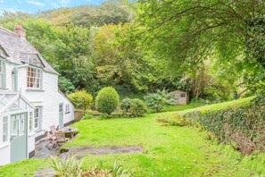 A white house with a stone pathway leading to a seating area. - 2 Bed in Boscastle (oc-f29161) (Boscastle)