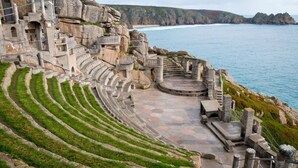 Un amphithéâtre en pierre, doté de gradins et d’une scène, qui offre une vue sur une zone côtière.