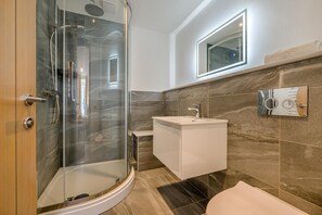 A modern bathroom with a glass-enclosed shower, a white sink, and a mirror above the sink. - 2 Bed in St. Ives (oc-e28156) (St Ives)