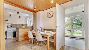 A modern kitchen with a dining area, wooden ceiling, and large windows. - 3 Bed in Walberswick (oc-s29097) (Walberswick)
