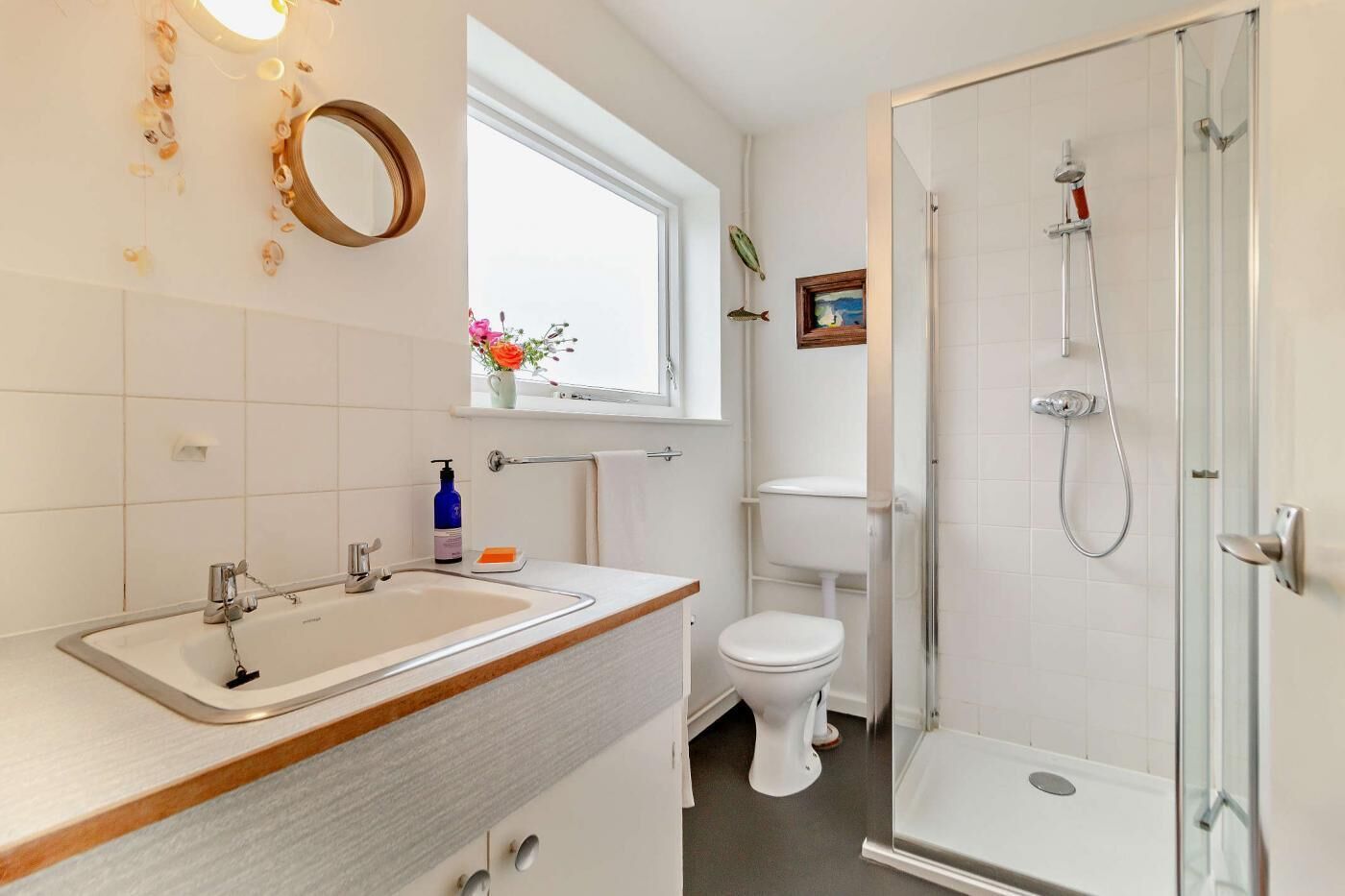Een moderne badkamer met een wastafel, toilet en douchecabine.