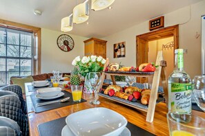 Une table dressée pour le petit-déjeuner, avec une présentation de fruits, une horloge et une bouteille de vodka Belvedere.