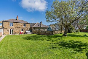 A stone house with a grassy yard, a tree, and a clear blue sky. - 4 Bed in Port Mulgrave (oc-r29068) (Port Mulgrave)