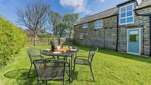 A stone house with a small garden and a round table with chairs. - 2 Bed in Port Mulgrave (oc-t29066) (Port Mulgrave)