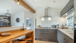 Een moderne keuken met een centraal eiland, roestvrijstalen apparatuur en een visgraat houten vloer.