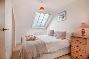Tabla de planchar con plancha y ropa de cama