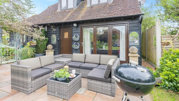 A house with a large patio area featuring a sectional sofa, a dining table, and a barbecue grill. - 1 Bed in Pluckley (oc-a29239) (Smarden)